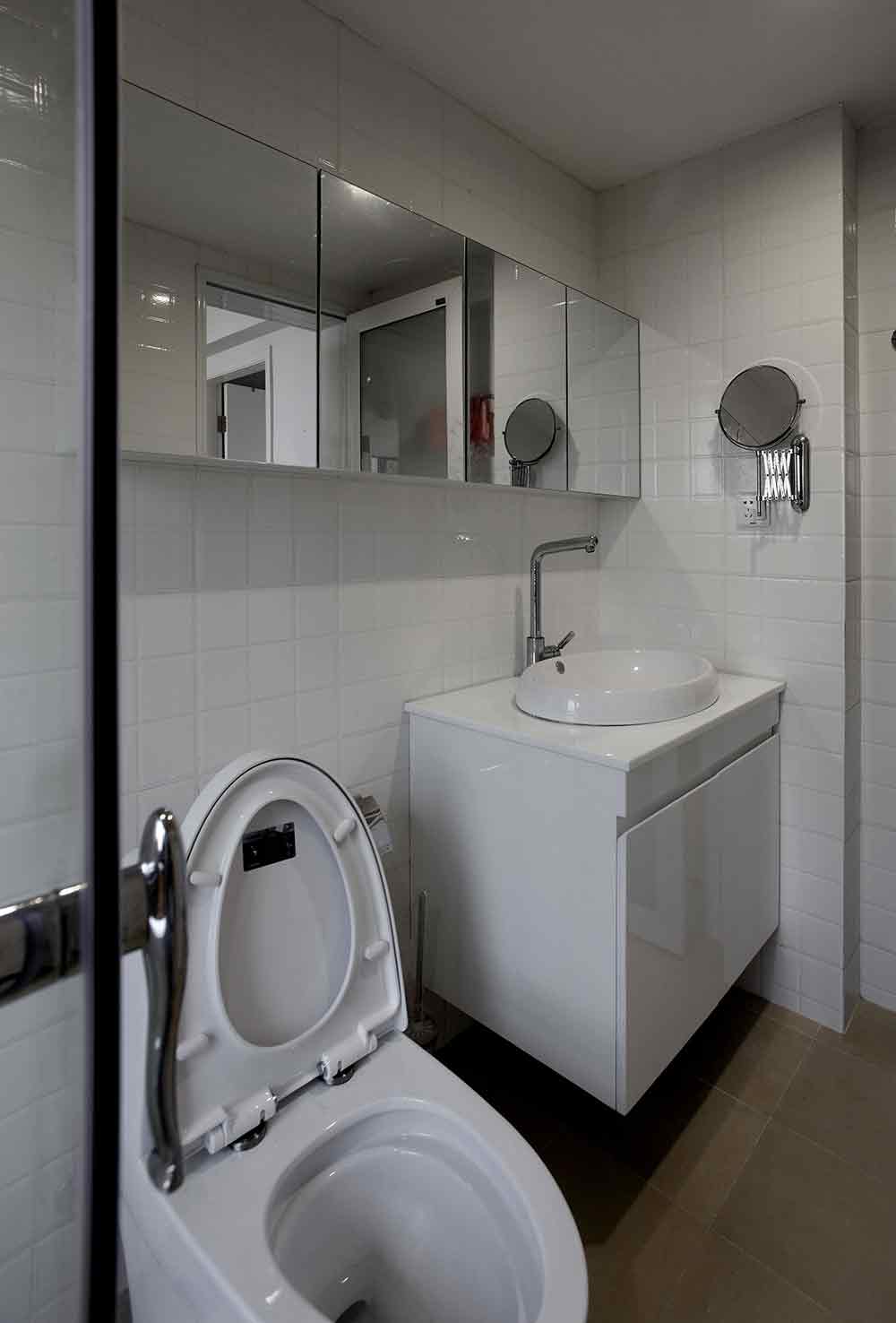 卫生间墙面以白色小方格瓷砖铺贴，清新可爱。拉长的镜面放大了空间感。