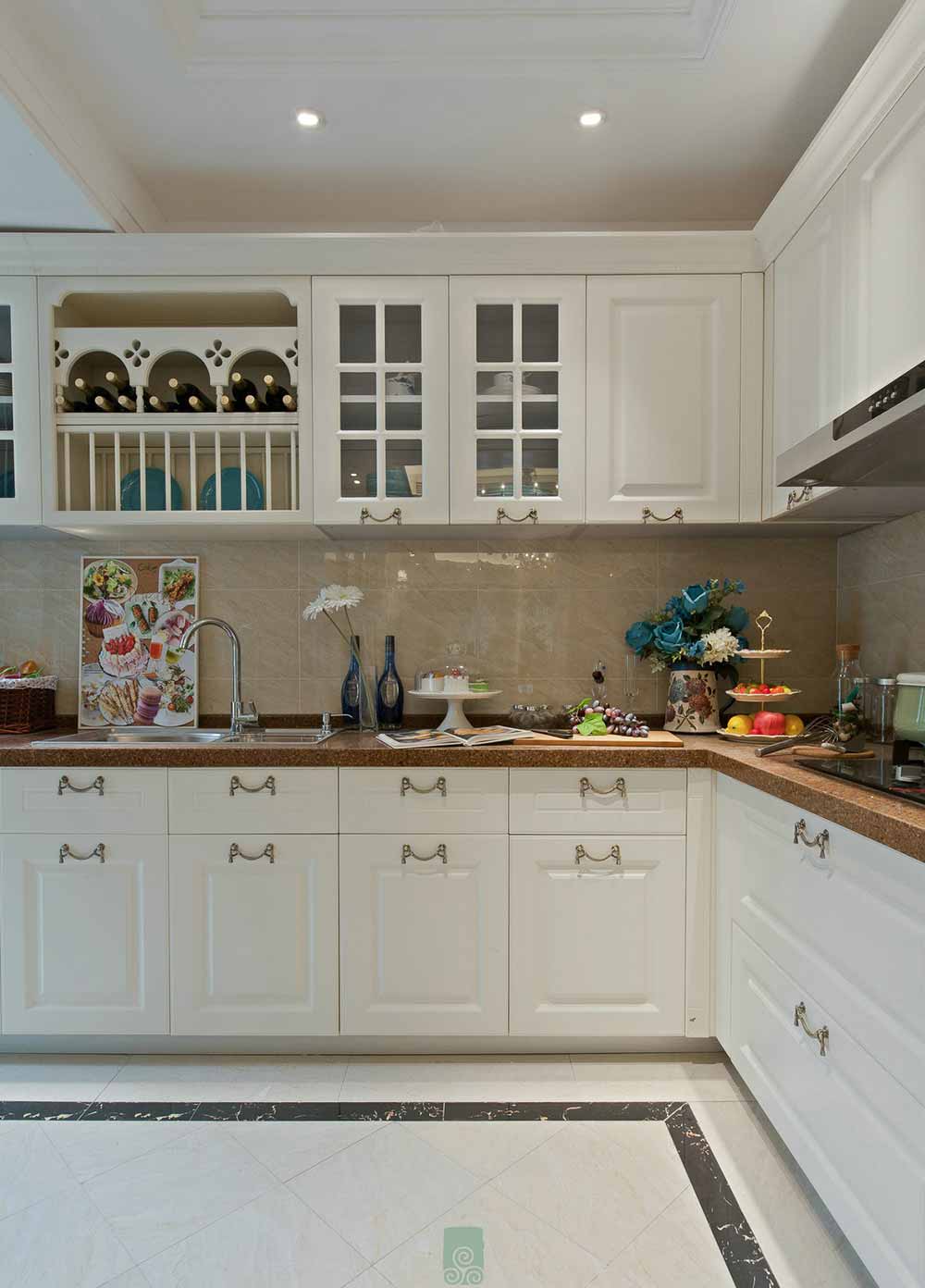 厨房的一体式白色橱柜功能齐全，设计精致。正方形的厨房空间宽敞而自如。
