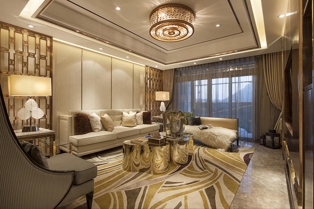 客厅圆柱体造型的桌子外部用金色花纹布艺包裹，贵气而不庸俗，与角落里弧形的软椅遥相呼应。