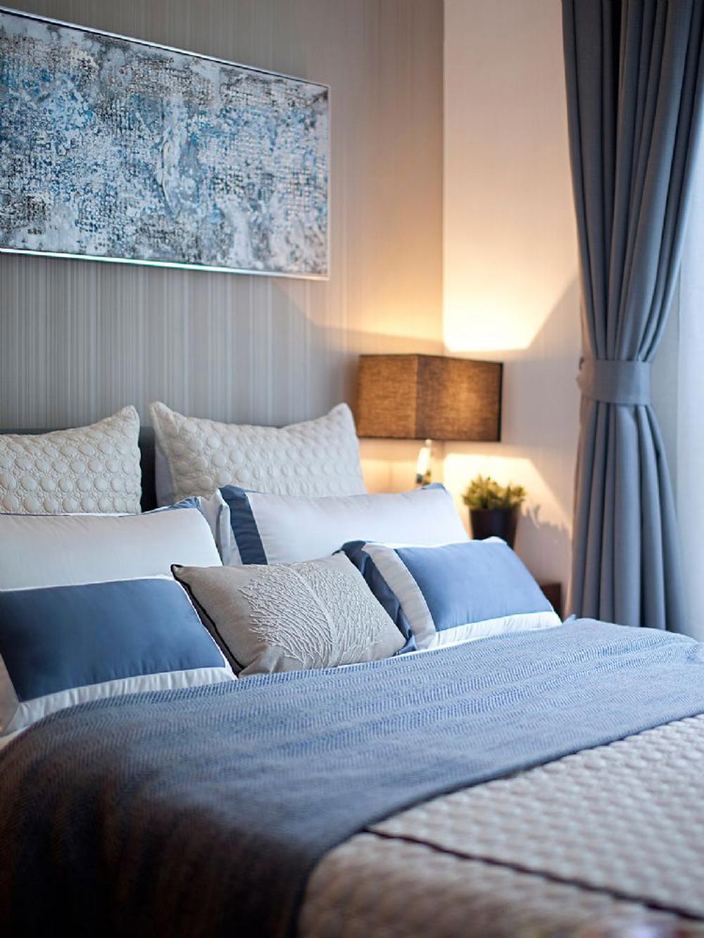 蓝色的窗帘和浅灰色的床单放在一起并不会冲突，反而更有情调。