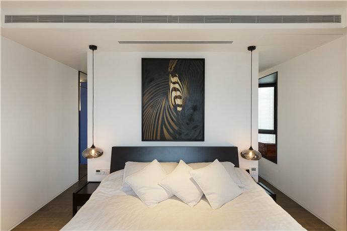 卧室的蓝色抽象画与蓝色的床头板上下呼应，把时尚感和艺术感巧妙带入空间。