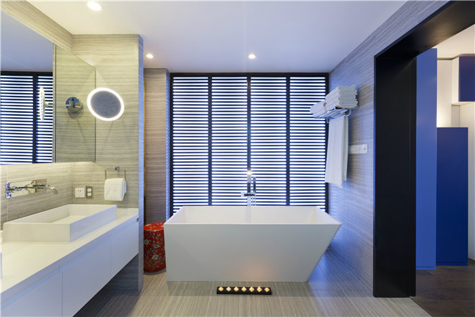 蓝色落地柜的光通过镜面折射进卫生间，和洗漱台边的浅蓝色现代装饰品相呼应，为空间营造出浪漫自由的氛围。