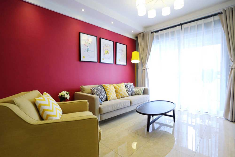 玫红色的沙发主墙面带有明艳动人的女性风格，配合沙发与软装的亮黄色系，搭配出了柔和的时尚美感。
