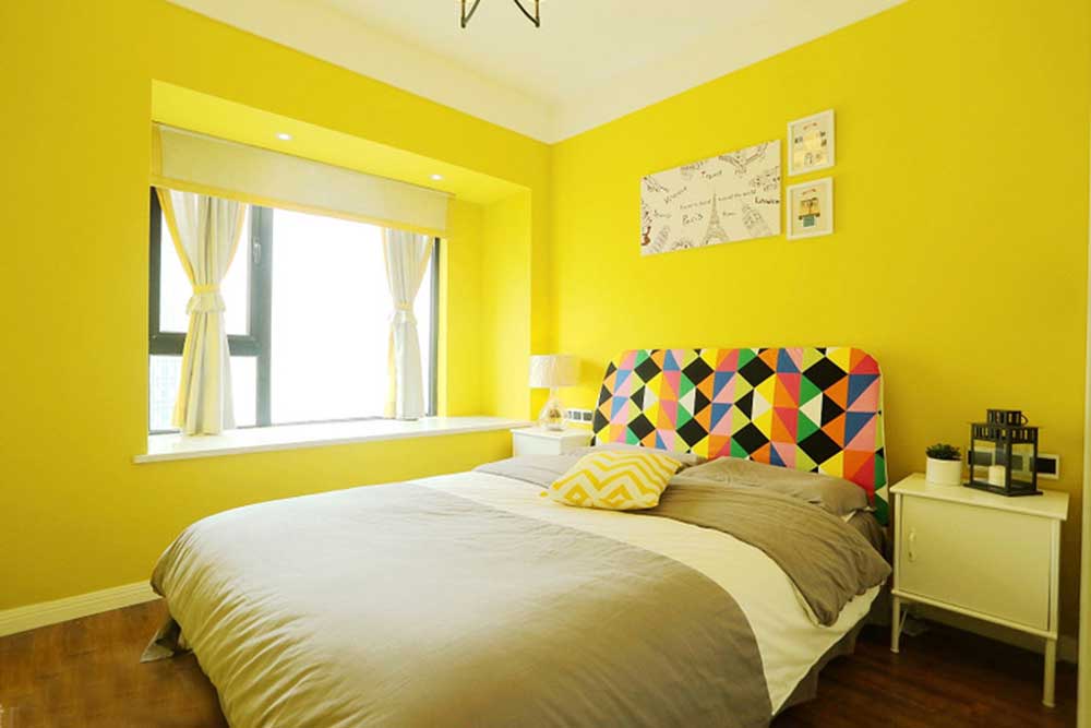 主卧以明黄色定调，与客厅家具有所呼应。床头几何图案的个性设计成为了空间中的精致点缀。