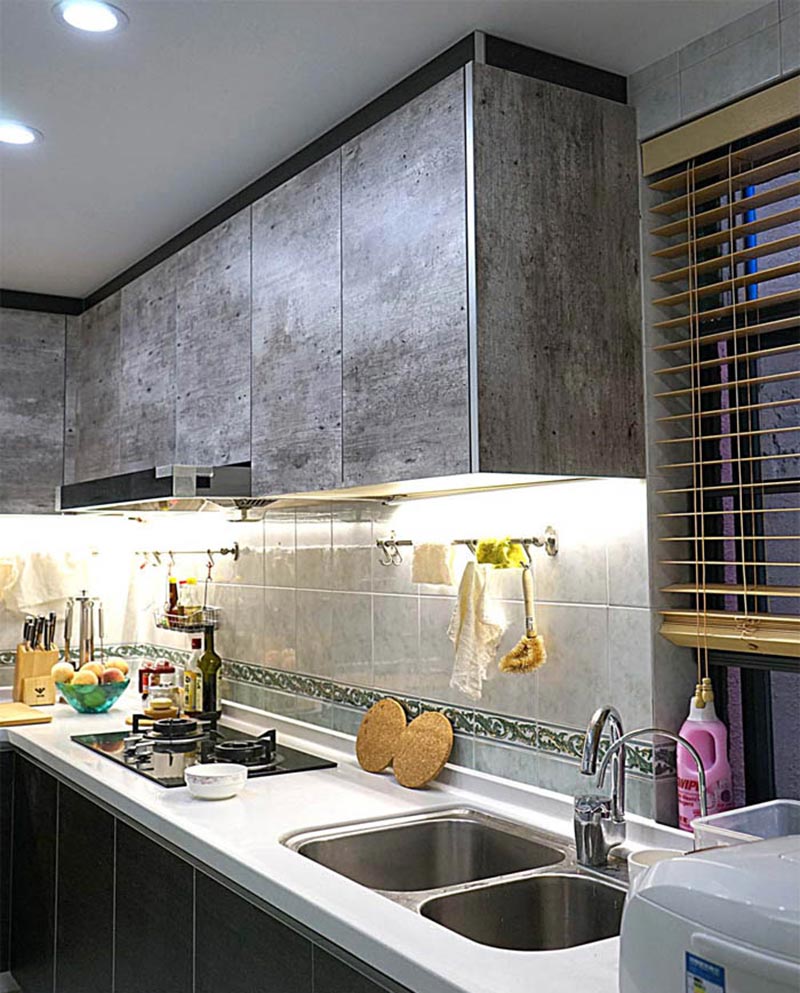 厨房的吊柜特别以水泥般质感的涂料装饰，在质朴中注入了复古的时尚元素。