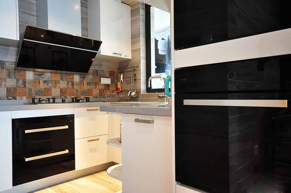 厨房空间以利落的黑白色调搭配，并加入了带有天然纹路的瓷砖点缀，丰富了视觉效果。