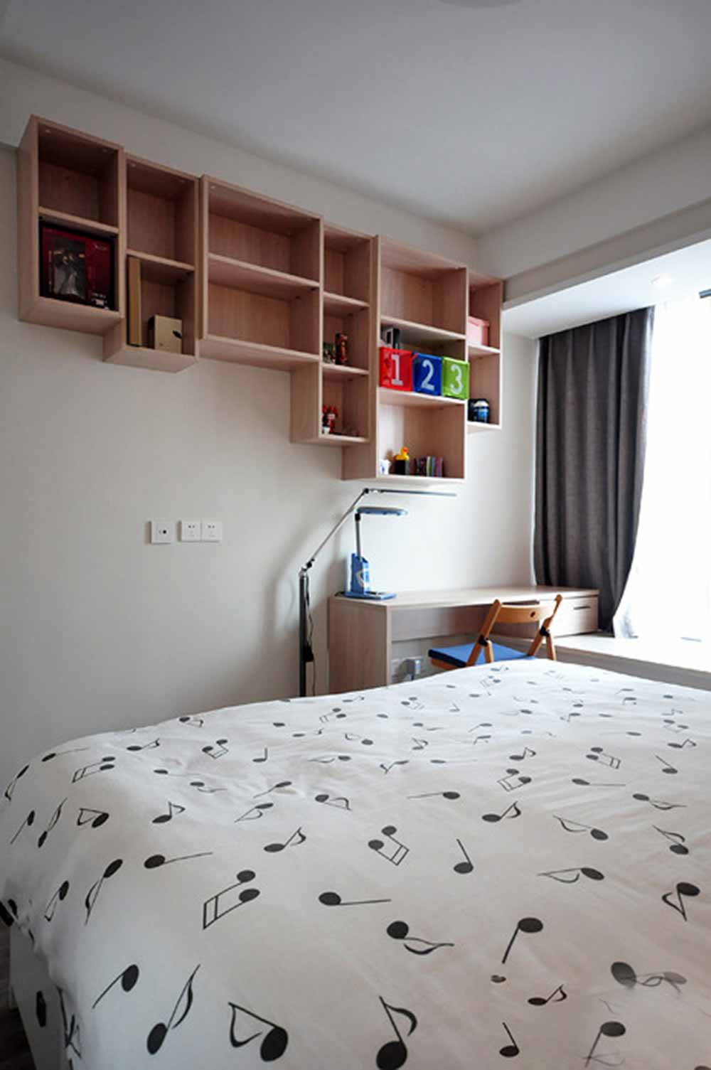 面积有限的卧室空间内，为了满足日常的收纳需求，设计师在墙面上安排了大量层板柜体，清新自然而实用。