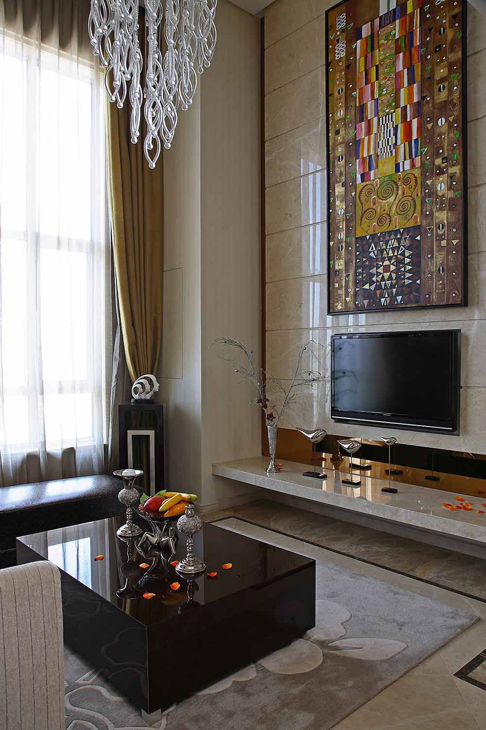 米黄色大理石质感的电视背景墙搭配上超大幅异域特色的挂画，整个客厅都丰富了起来。