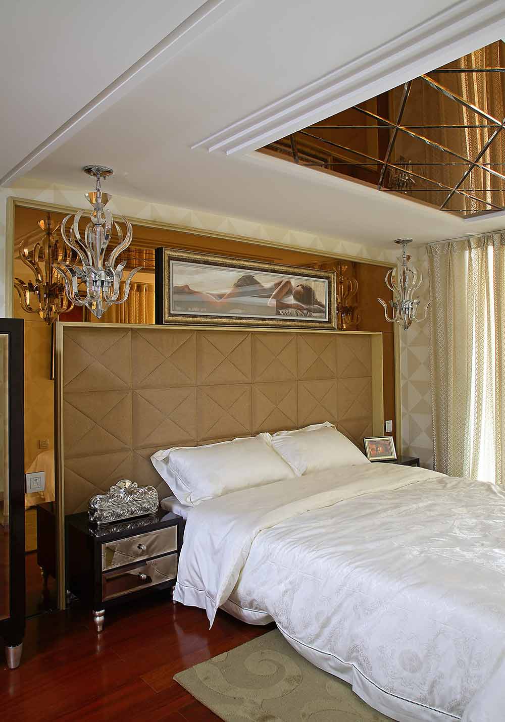 卧室部分，金色镜面设计的背景墙与顶部镜面相互搭配尽显时尚，床头皮质软包让卧室感觉更舒适温馨。