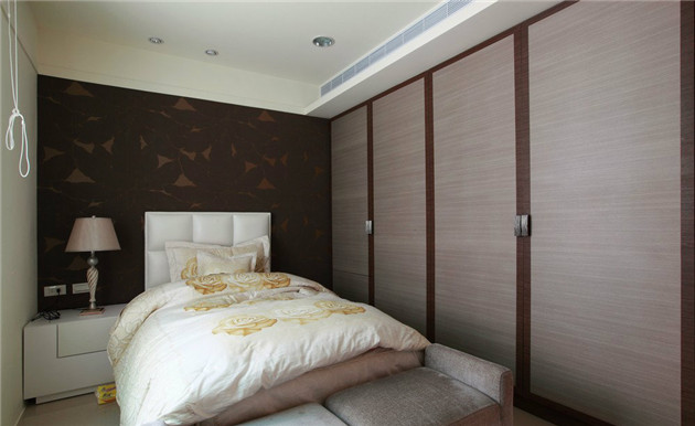 立体造型的床头墙面，更显空间的轻盈自在。衣柜选用的是秋香木搭配胡桃木，兼顾了设计感与机能性。