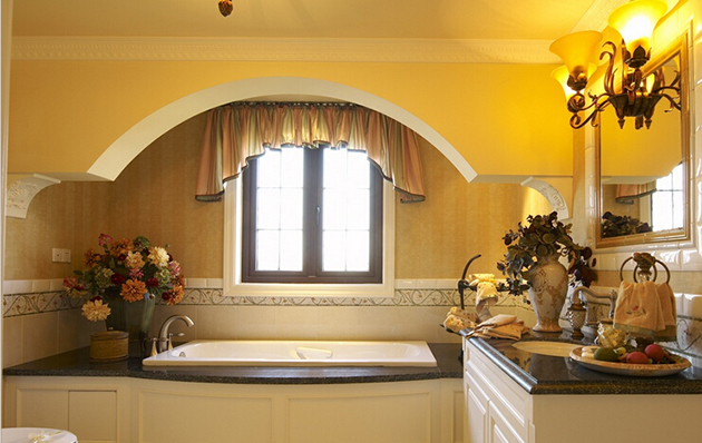 浴室用鲜花的装饰，暖黄的灯光，让人很想好好的躺在浴缸里泡个澡。