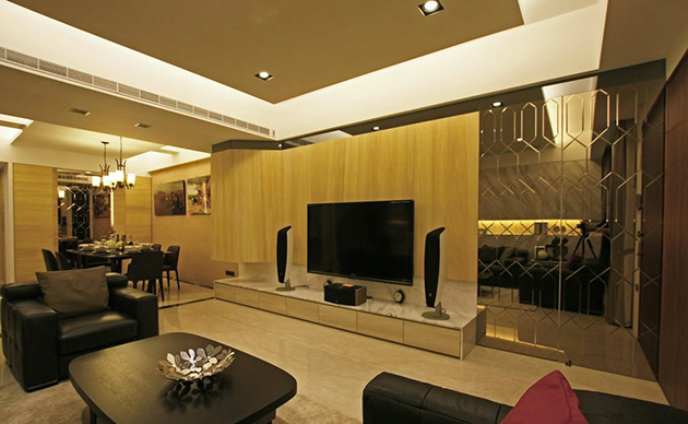 为强化电视主墙与空间的宽幅比例，设计师以材料为分割线，天然梧桐木佐以灰镜带出局部反射的视觉效果。