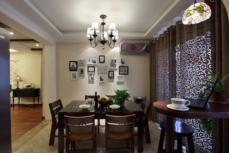 餐厅的餐桌选择实木为主，深红色的实木餐桌搭配纹样丰富的餐具相得益彰，餐厅墙面的照片墙将来会是整个家旅游归来的分享区。