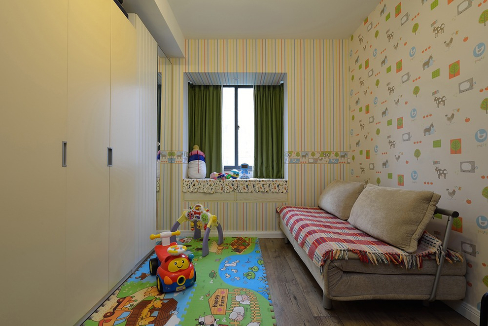 小小的儿童房里贴满色彩墙纸，小飘窗外加墨绿窗帘，带来童话故事里的缤纷想象。用沙发床替代普通的儿童床，节省了占地空间，白天有客人来访，这里可以暂且当娱乐室一用。