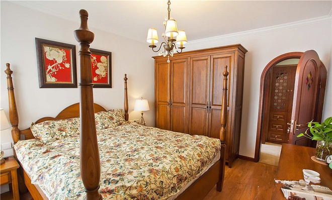 主卧的大床用的是美式田园风格的四柱床，四门实木衣柜美观实用，与整体色调又相互映衬，拱形木门的设计则平添了可爱的气息。