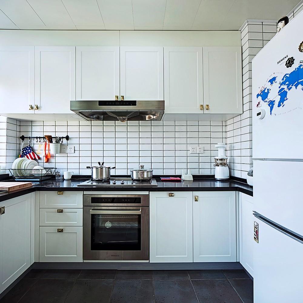 厨房空间使用了面包砖与白色的橱柜形成干净简洁的半开放式空间，配上旅行主题的冰箱贴点缀活泼的氛围。