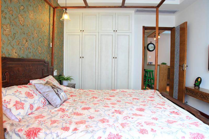 映入眼帘的床单是喜庆的红花，卧室的壁纸也是复古的花纹。