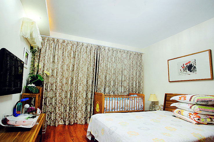 卧室的搭配混搭风十足，中式水墨风的画，简约木式床，田园花式窗帘，展现主人独特审美。