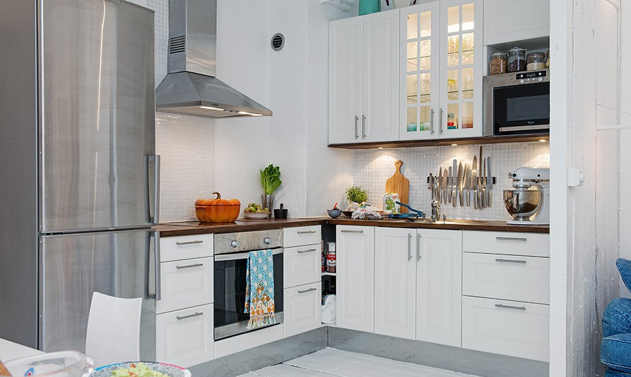开放式厨房，顶吸式油烟机，木工板与彩色地毯使厨房与客厅的空间得以划分。