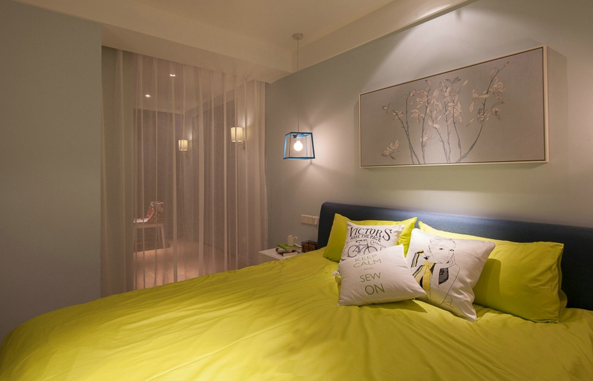 主卧的被套枕头都是黄色的，很亮眼的颜色，墙体挂画较为浅淡，和谐美好。