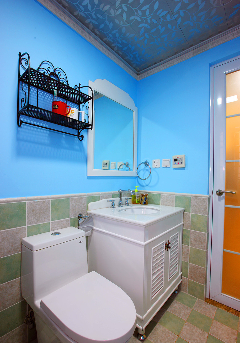 卫生间同样也需要设计，蓝色墙面搭配灰绿相间的瓷砖，清新自然。