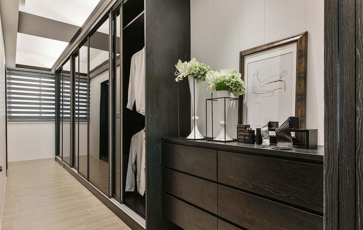 主卧同一层楼的更衣空间，以整洁简约的收纳设计规划，并带入黑镜元素，亦可作为穿衣镜使用。