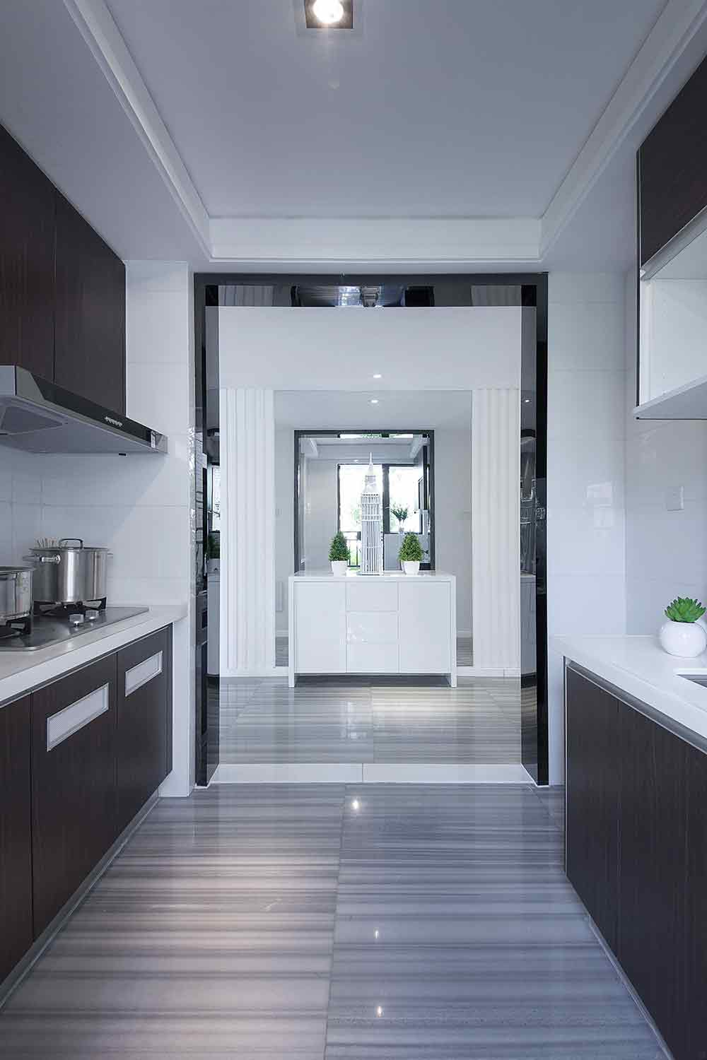 厨房采用半开放式的设计，通透而独立，深灰色橱柜和门框的搭配和谐一致。