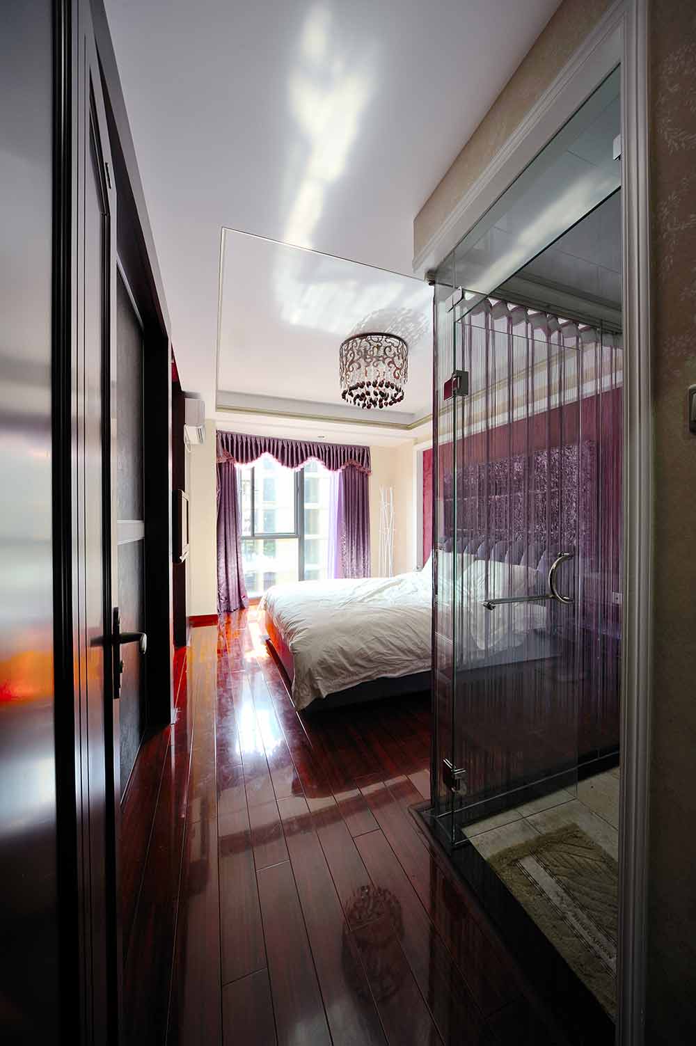 卧室整体采用了紫色调的装饰， 玻璃门全包裹的卫生间让卧室不受潮气影响。