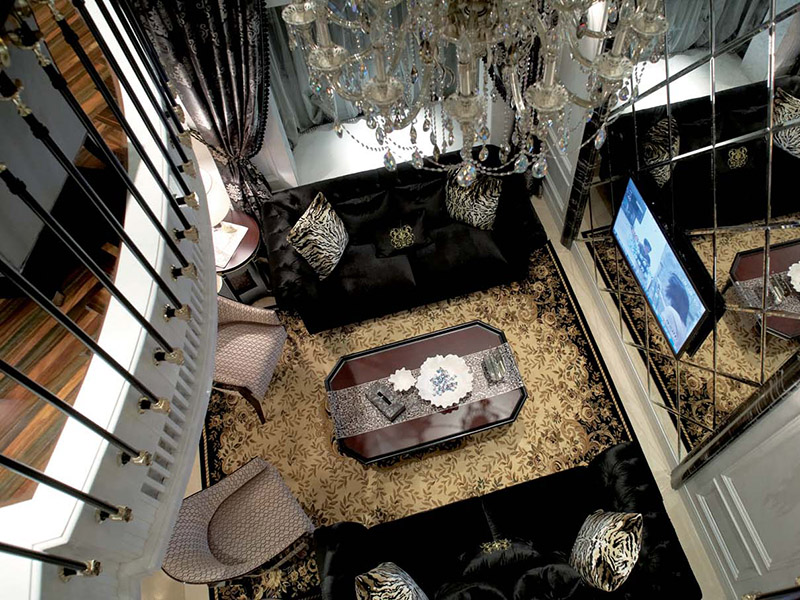 从二楼俯瞰客厅，地毯的花纹和玲珑的吊灯烘托出整个空间的华丽感。