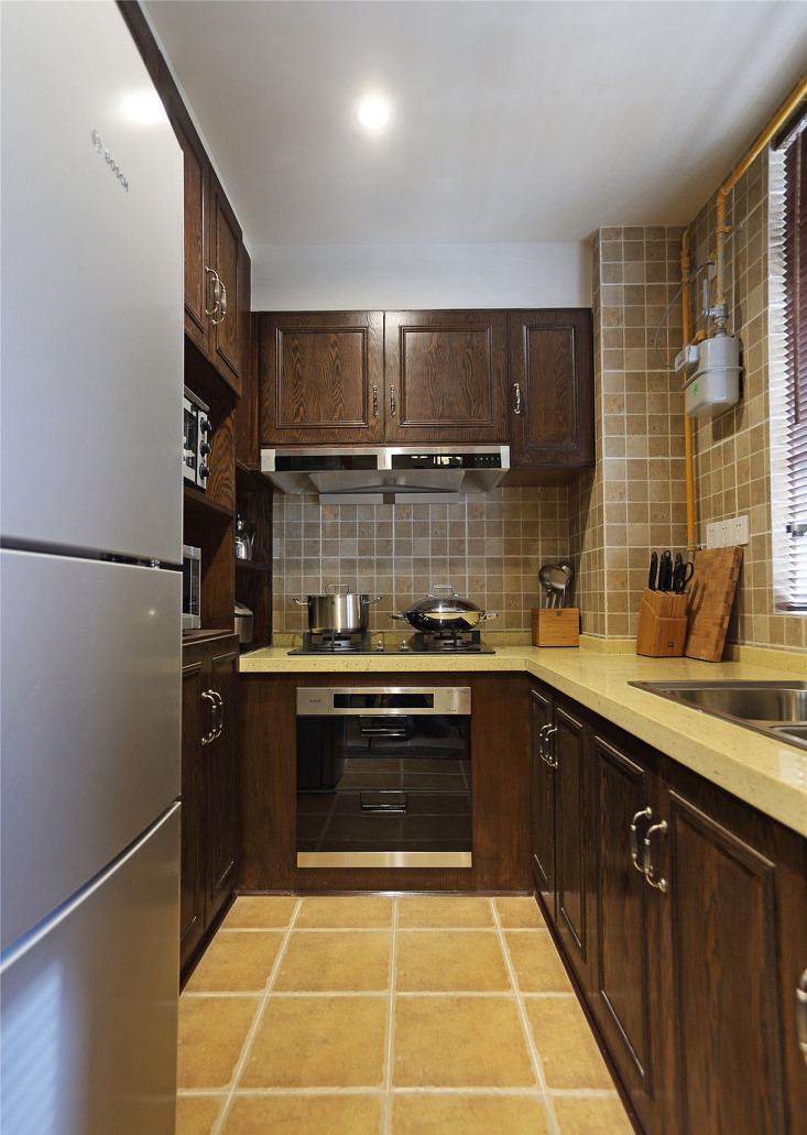 深棕的橱柜与浅黄色的大理石板面，有着厨房本身的干练，又多了一丝美食般的温度。