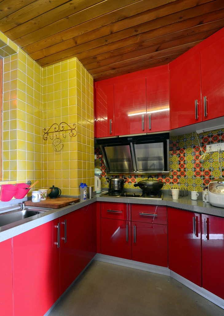 红色是波西米亚风格中用的最多的颜色，尤其是在厨房。环绕型的红色厨房，用正方形拼接的黄色瓷砖搭配，小空间里的独特风情。