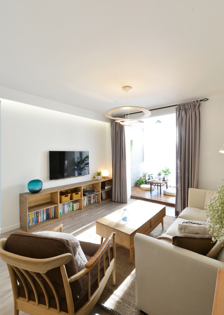 宽敞的客厅用原木家具隔离出空间，米色的布艺沙发把整体的情调变得小资清雅。