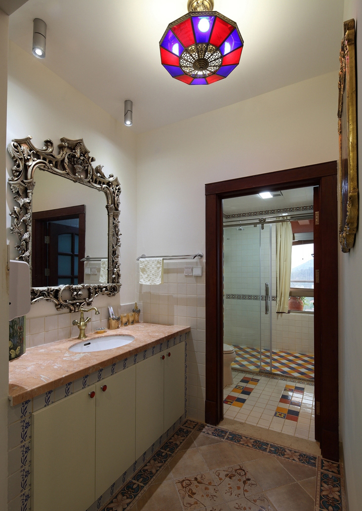 洗手间内，无论是地砖还是橱柜，甚至是镜子都有着欧式花纹的设计。