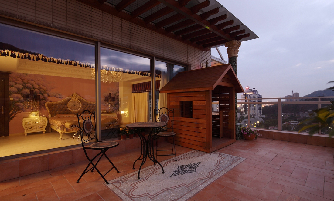 木质小房子加上几张金属桌椅，简单的几个元素，把阳台装饰得休闲惬意。