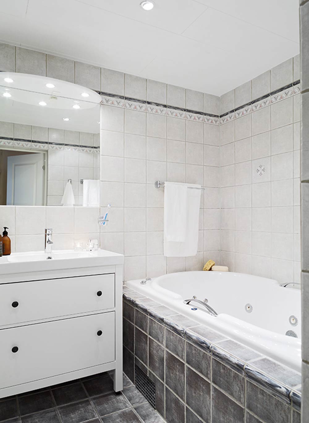 卫生间的空间利用十分巧妙，浴缸旁的洗手台还带有储物功能，为生活带来便利。