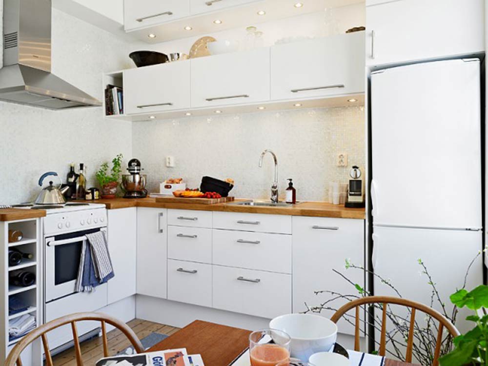 厨房以整排的白色橱柜为主体，整体明亮而宽敞。