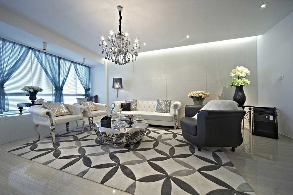 客厅十分宽敞，黑白两色的皮质沙发舒适大方。沙发凳脚与地砖冰冷的反射被简约大方的地毯中和了。