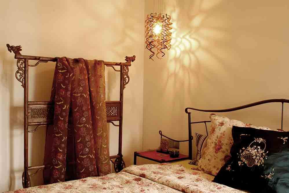 床边摆放以木质雕琢的衣架，精致美观，方便实用。