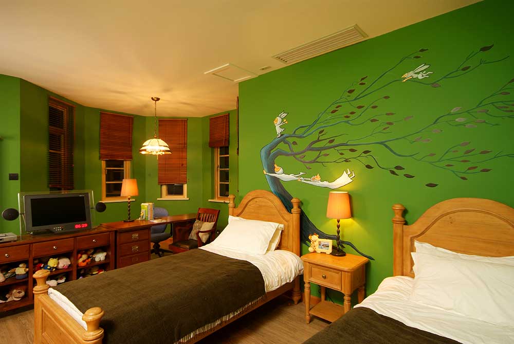 儿童房整体较为清新，墙面上的绿色插画让人眼前一亮。