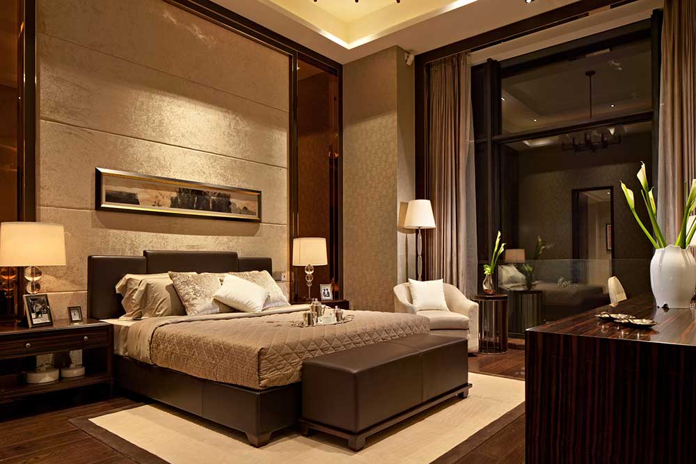 卧室背景墙以金色丝绒装饰与床头等宽的装饰画，皮质床尾凳方便衣物的放置，美观实用。