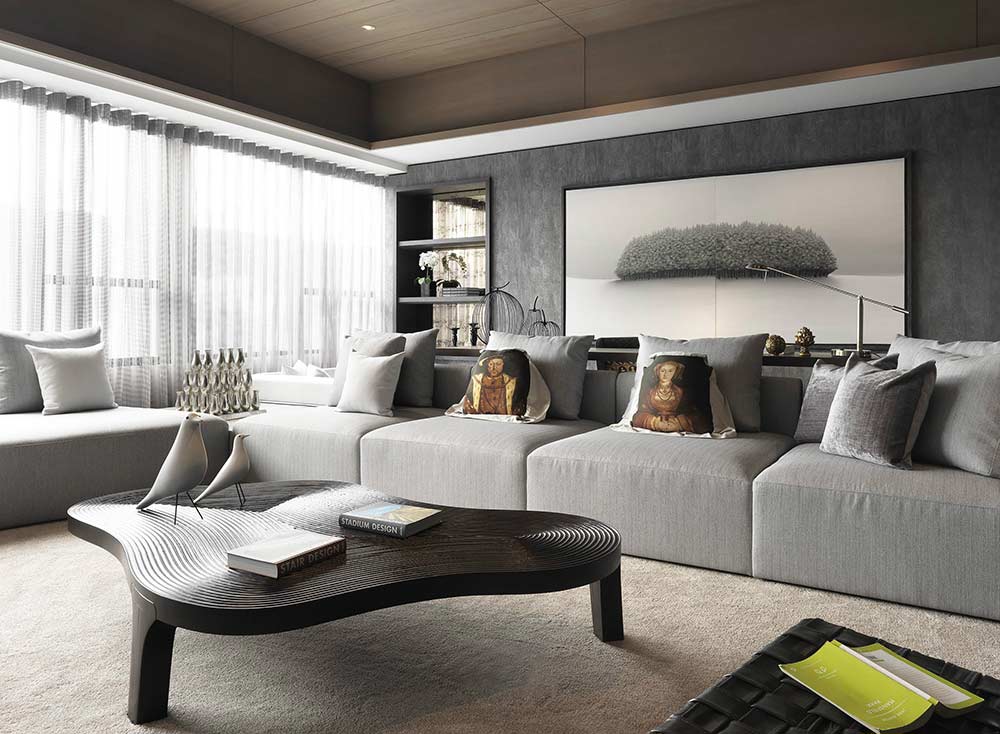 客厅灰色的布艺沙发看起来休闲舒适，创意的木质茶几是整个空间最出彩的地方，独特的造型带着不对称的美感。