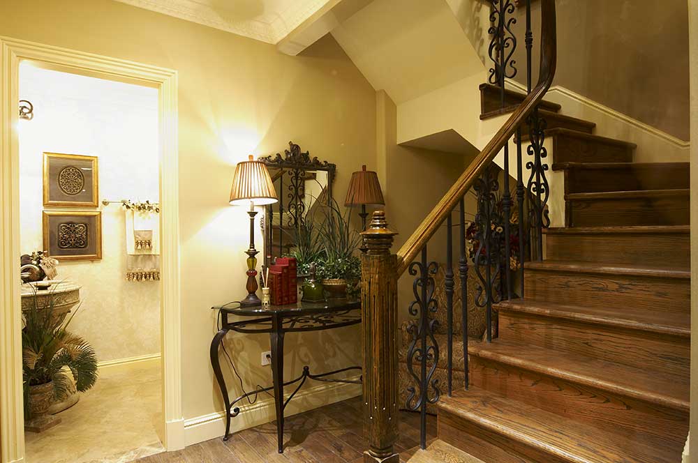 别墅楼梯蜿蜒上盘，实木台阶、实木扶手，配上欧式花纹的栏杆，融合在整个欧式风格的别墅空间中。