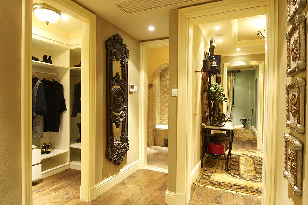 主卧衣帽间用隔墙隔开，简单优雅，雕花实木镜子让衣帽间也充满了高贵和典雅。墙上的装饰画画框非常富贵。