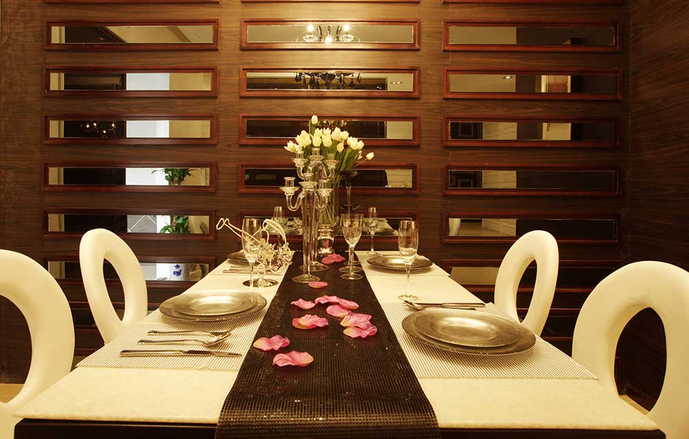 餐厅的装饰富有现代感也结合了中式风，红褐色的实木隔断墙，隔开了卧室和餐厅，乳白色的桌布和椅子，很舒服。