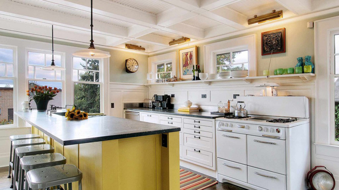 半开放式厨房，整洁靓丽。黄色的吧台带着操作台的功能。在橱柜设计上省略了繁重的吊柜设计，更为清爽。