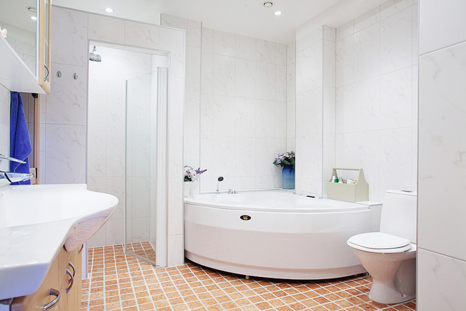 卫生间的设计以干净实用为主，靠墙的半圆浴缸节省空间，淋浴房用透明玻璃门隔成相对独立的空间。