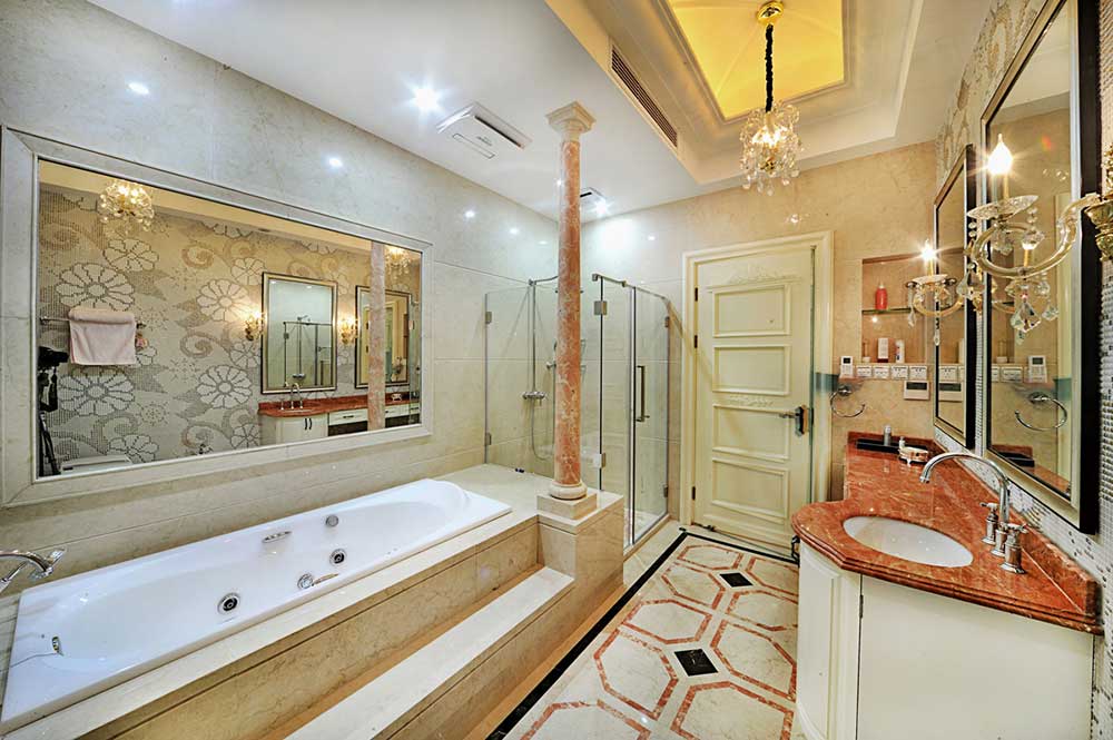 主卧卫生间保持色调一致，造型上就像是微缩版的客厅，缩小版罗马柱、乳白浴缸抬高装修，红色大理石台面，很美丽。