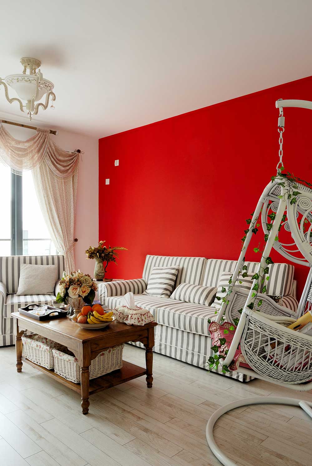 红色的墙面是客厅装修的重点，淡雅的灰色条纹沙发增添时尚感