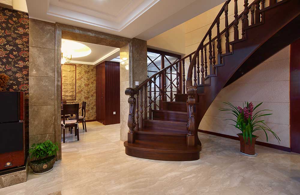 楼梯盘旋而上，红褐色的实木台阶和扶手，和整个客厅的色调相配合起来，功能区之间过渡自然。
