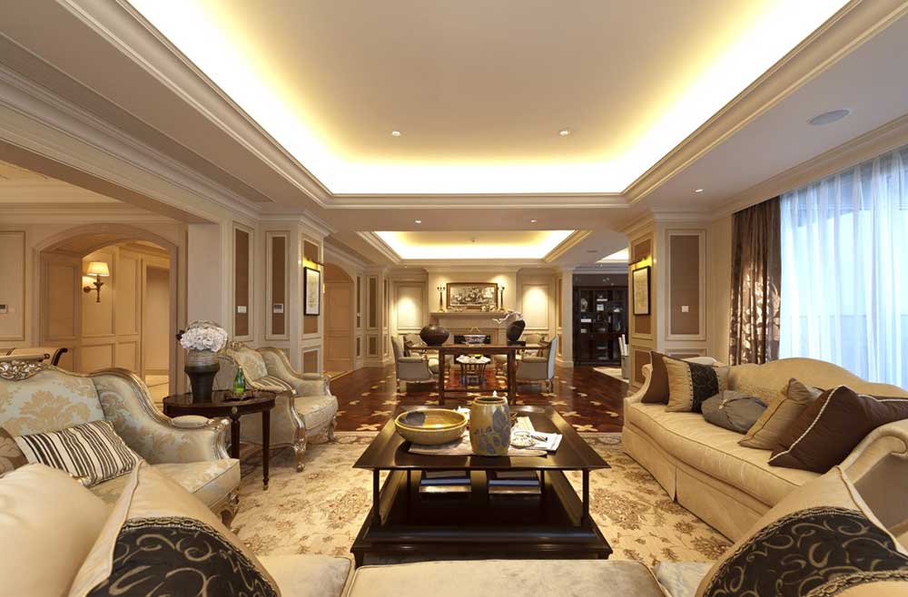 客厅的装饰简单大方，沙发摆放和客厅的形状相呼应，都是方形的。吊顶装饰的简单明亮，黄色灯带照亮整个空间。